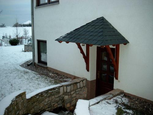 une porte d'une maison avec un parasol dans l'établissement Ferienwohnung Thiele, à Wettelrode