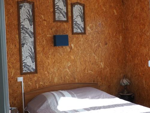 1 dormitorio con 1 cama con 4 cuadros en la pared en Mon gîte au Jura en Lavans-lès-Saint-Claude
