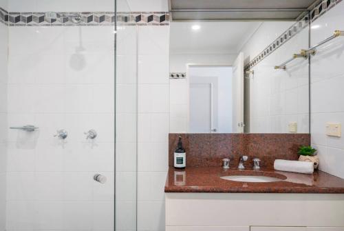 een badkamer met een wastafel en een douche bij Spectacular Darling Harbour View Apartment & Parking in Sydney
