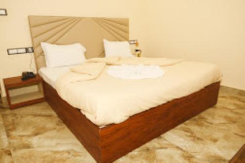een slaapkamer met een groot bed met witte lakens bij New Standard Hotel , Gorakhpur in Gorakhpur