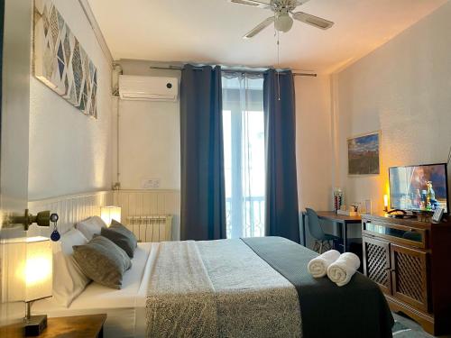 a bedroom with a bed with blue curtains and a window at Itinere Rooms in Granada