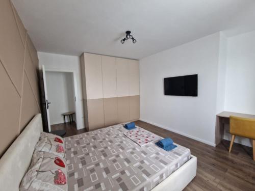 a small bedroom with a bed and a desk at Blue apartment nearby Amethyst & Vivo Mall in Floreşti