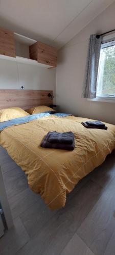 een slaapkamer met een bed en 2 badjassen bij Le Mérou in Saint-Projet