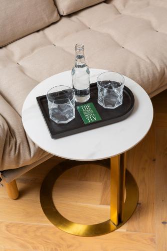 a white table with two glasses and a bottle on it at Jewel TLV Hotel in Tel Aviv