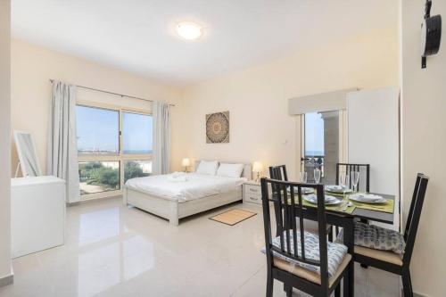 a bedroom with a bed and a table and chairs at New Listing - Pool & Beach View - Czechin - RAK in Ras al Khaimah