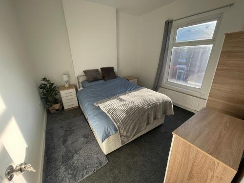 een slaapkamer met een bed en een raam bij Spacious 4-Bedroom House in Manchester in Manchester