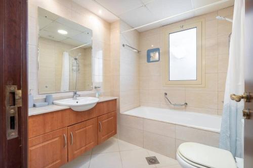 a bathroom with a sink and a tub and a toilet at New Listing - Pool & Beach View - Czechin - RAK in Ras al Khaimah