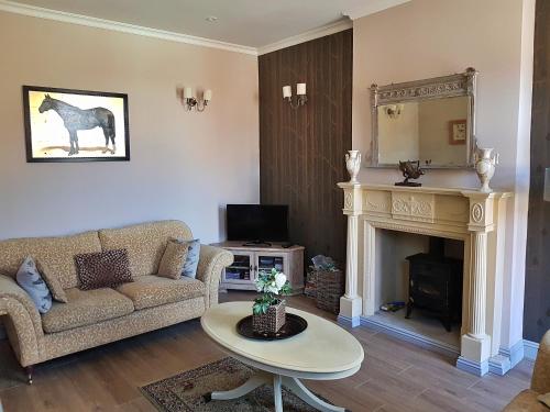 a living room with a couch and a fireplace at Finest Retreats - No 3 Meynell Mews in Breedon on the Hill