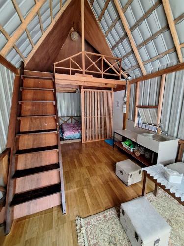 a loft bed in a room with a staircase at Palanta Roemah Kajoe Syariah Villa in Kampungdurian