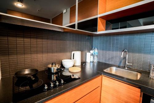 a kitchen with a stove with pots and pans on it at Thonglor Modern Luxury Condo in Bangkok