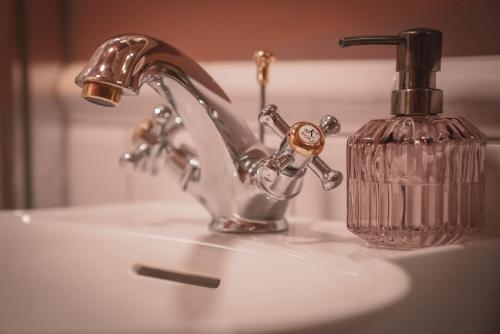 a sink with a faucet and a soap bottle at Villa Havblikk Tromsø in Tromsø