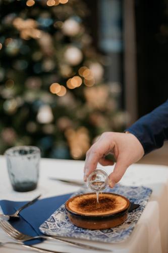 a person holding a glass over a plate of food at Kyriad Metz Centre - Restaurant Moze in Metz