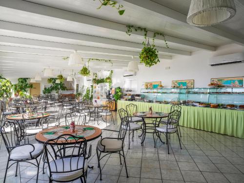 un restaurante con mesas y sillas en una habitación en Stromboli Trekking Accommodation - Room and Excursion for 2 included, en Stromboli