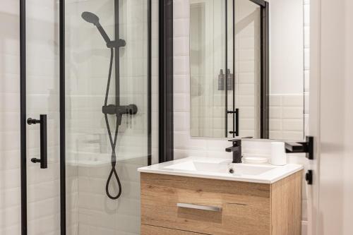 La salle de bains est pourvue d'un lavabo et d'une douche. dans l'établissement BNBHolder Best VI Madrid Rio, à Madrid