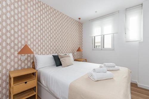 a bedroom with two beds with towels on them at BNBHolder Best VI Madrid Rio in Madrid