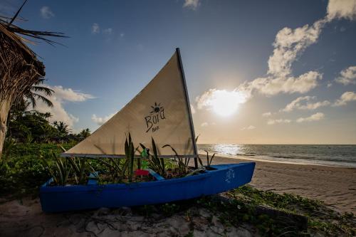 a boat on the beach with the sun in the background at Moriah Maceió Beach Hotel in Maceió