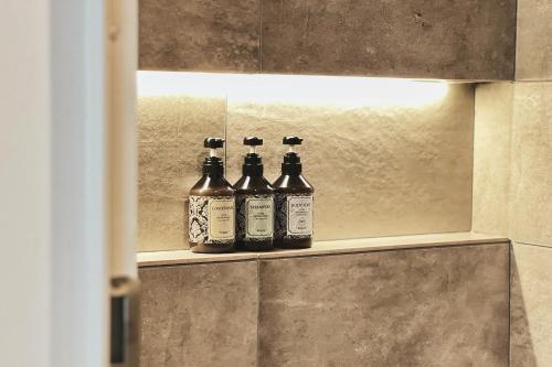 three bottles of alcohol sitting on a shelf in a bathroom at Exquisite business hotel Bella in Tokyo