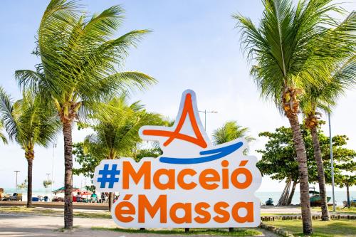 a sign for a marina in a resort with palm trees at Moriah Maceió Beach Hotel in Maceió