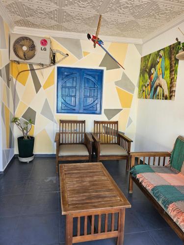 a room with chairs and tables and a mural at Casa da Mãe Barra Grande in Maragogi