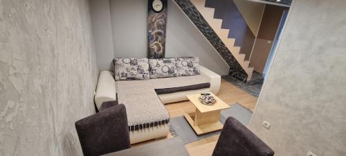 ein Wohnzimmer mit Couch und Tisch in der Unterkunft Apartman Centar 2 in Subotica