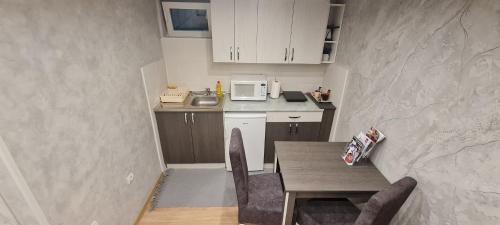 a small kitchen with a table and a microwave at Apartman Centar 2 in Subotica