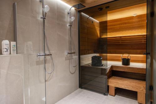 a shower with a glass door in a bathroom at Brand new Arctic snowstar apartment in Rovaniemi