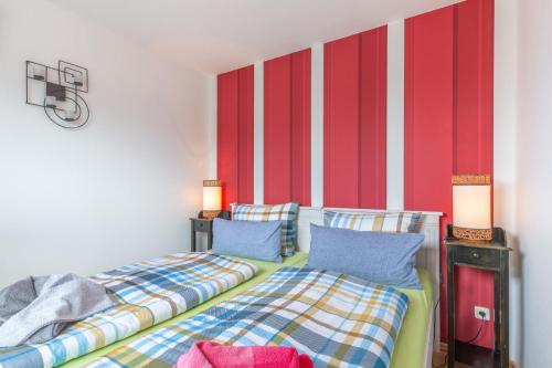 twee bedden in een kamer met rode en witte strepen bij OSTSEE-Ferienhaus RAMONA - am Strand & ruhig in Hohenkirchen