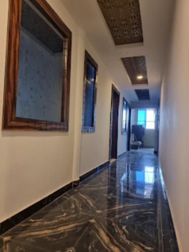 um corredor com piso de mármore e uma pintura na parede em Hotel Shanti Grand Inn , Gorakhpur em Gorakhpur