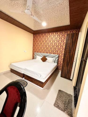 a small bedroom with a bed and a chair at Hotel Shanti Grand Inn , Gorakhpur in Gorakhpur