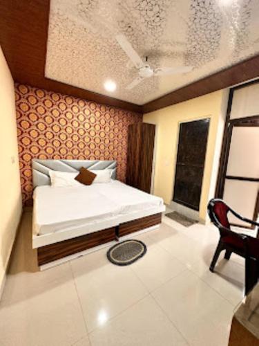 ein Schlafzimmer mit einem Bett und einem Stuhl darin in der Unterkunft Hotel Shanti Grand Inn , Gorakhpur in Gorakhpur