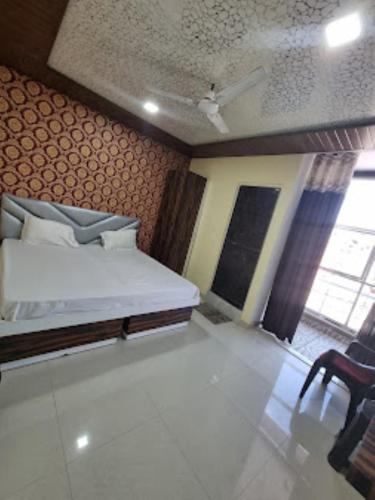 ゴーラクプルにあるHotel Shanti Grand Inn , Gorakhpurのベッドと椅子が備わる小さな客室です。