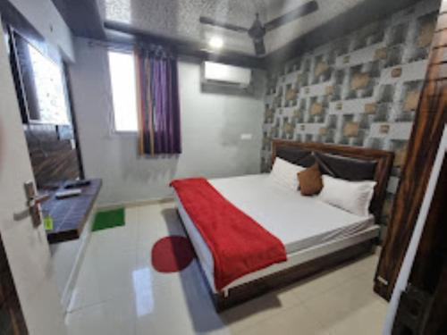 a bedroom with a bed with a red blanket at Hotel Shanti Grand Inn , Gorakhpur in Gorakhpur