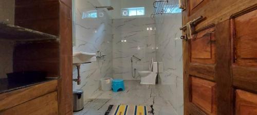Baño blanco con 2 aseos y lavamanos en The Connoisseur, en Baihar