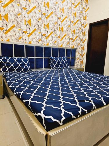 Una cama azul y blanca en una habitación en Rose Palace Hotel Karachi en Karachi