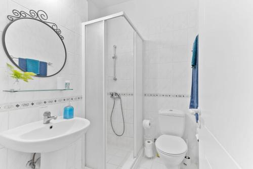 a bathroom with a shower and a toilet and a sink at Limnaria Gardens Cozy Apartment in Paphos City
