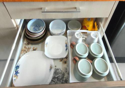 a drawer filled with plates and cups and bowls at Dpulze Comfy Homestay, 1-5 Pax - DP3 in Cyberjaya