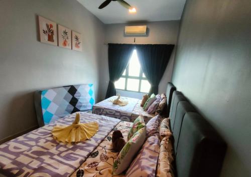 a bedroom with two beds and a window at Dpulze Comfy Homestay, 1-5 Pax - DP3 in Cyberjaya