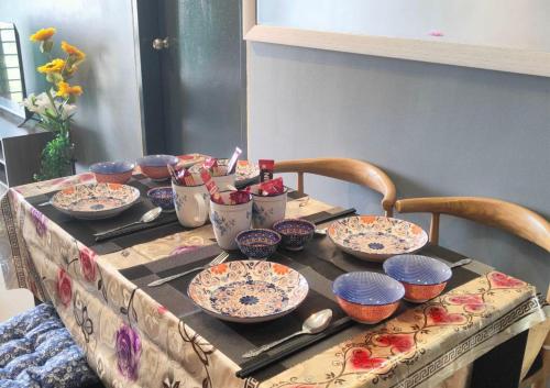 a table with a bunch of bowls and plates on it at Beauty Park View Stay Above DPulze Mall #DP3 in Cyberjaya