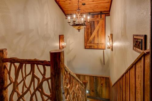 a wooden staircase with a chandelier in a house at Rivers Edge at Eagles Nest in Banner Elk