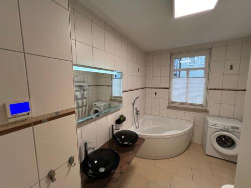 y baño con bañera y lavadora. en Apartment Humboldt 3 Schlafzimmer,Wifi, Netflix Parken, Terrasse, klimatisiert, nähe Zentrum, en Jena