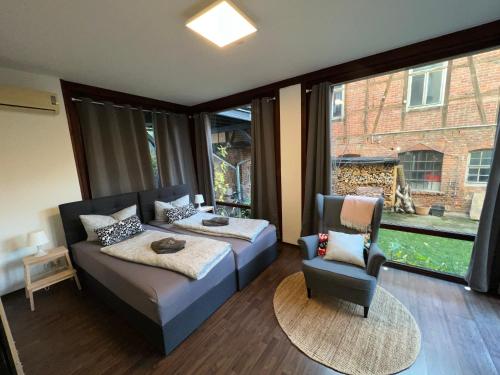 Un dormitorio con una cama y una silla y una ventana. en Apartment Humboldt 3 Schlafzimmer,Wifi, Netflix Parken, Terrasse, klimatisiert, nähe Zentrum, en Jena