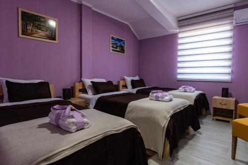 a room with four beds with purple walls at Smestaj & Spa Protić in Šabac