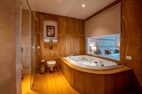 1 dormitorio y baño grande con bañera. en The Fern Surya Resort Kasauli Hills, Dharampur, en Kasauli