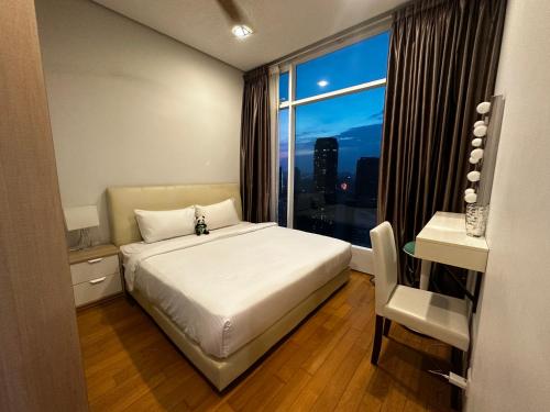 een slaapkamer met een bed, een bureau en een raam bij Lovely 2&3bedrooms condo klcc and kL tower view in Kuala Lumpur