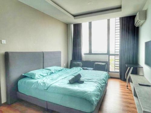 - une chambre avec un lit avec un animal rembourré dans l'établissement Cozy Homestay Vivacity Megamall, à Kuching