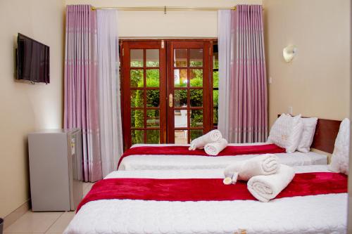 two beds in a room with towels on them at Matilinda Lodge in Bulawayo