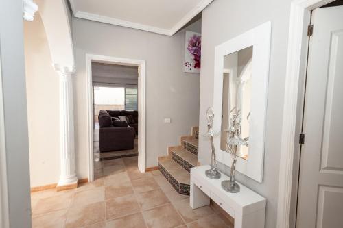 a living room with a staircase and a mirror at Villa Vanesa luxury private villa with a heated pool, 4 bedrooms and 4 bathrooms in Adeje