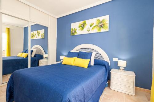 a blue bedroom with a bed and a mirror at Villa Vanesa luxury private villa with a heated pool, 4 bedrooms and 4 bathrooms in Adeje