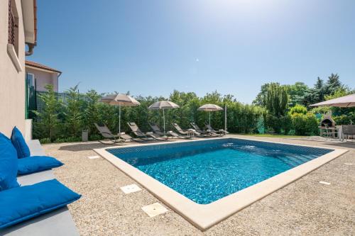 Vinež的住宿－Villa Giovanni Maria，庭院内的游泳池,配有椅子和遮阳伞