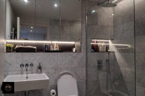 een badkamer met een douche, een toilet en een wastafel bij Lovely 3-Bed Apartment in Altrincham in Altrincham